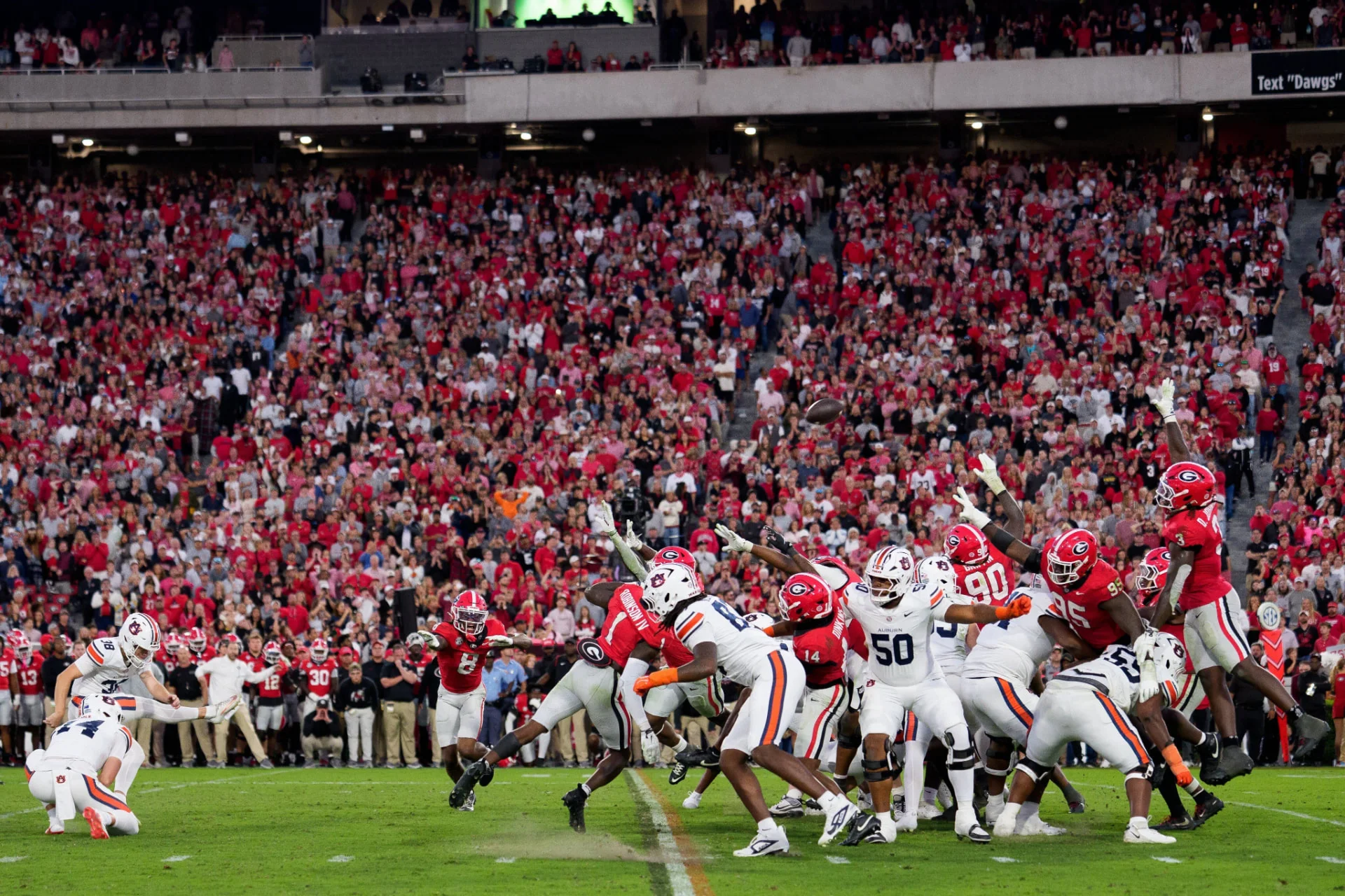 Photo offered with the commemorative frame: Alex McPherson kicks the game-winning field goal against Georgia, with the holder on the left and the football in flight